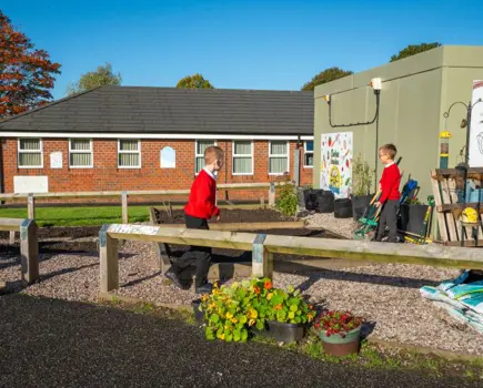 Two children in the vegetable gardens at Millbrook Primary school